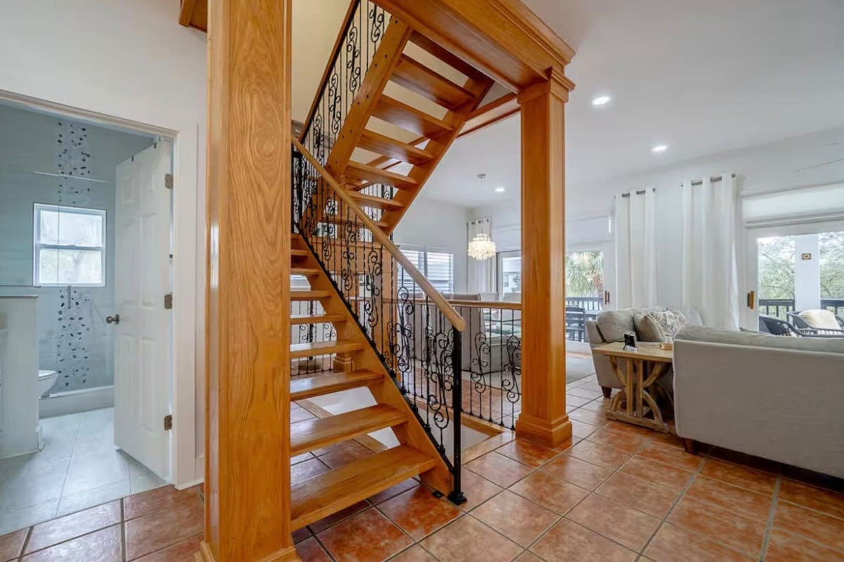 Grand wooden staircase and open-concept architectural details welcoming guests into the main living space.