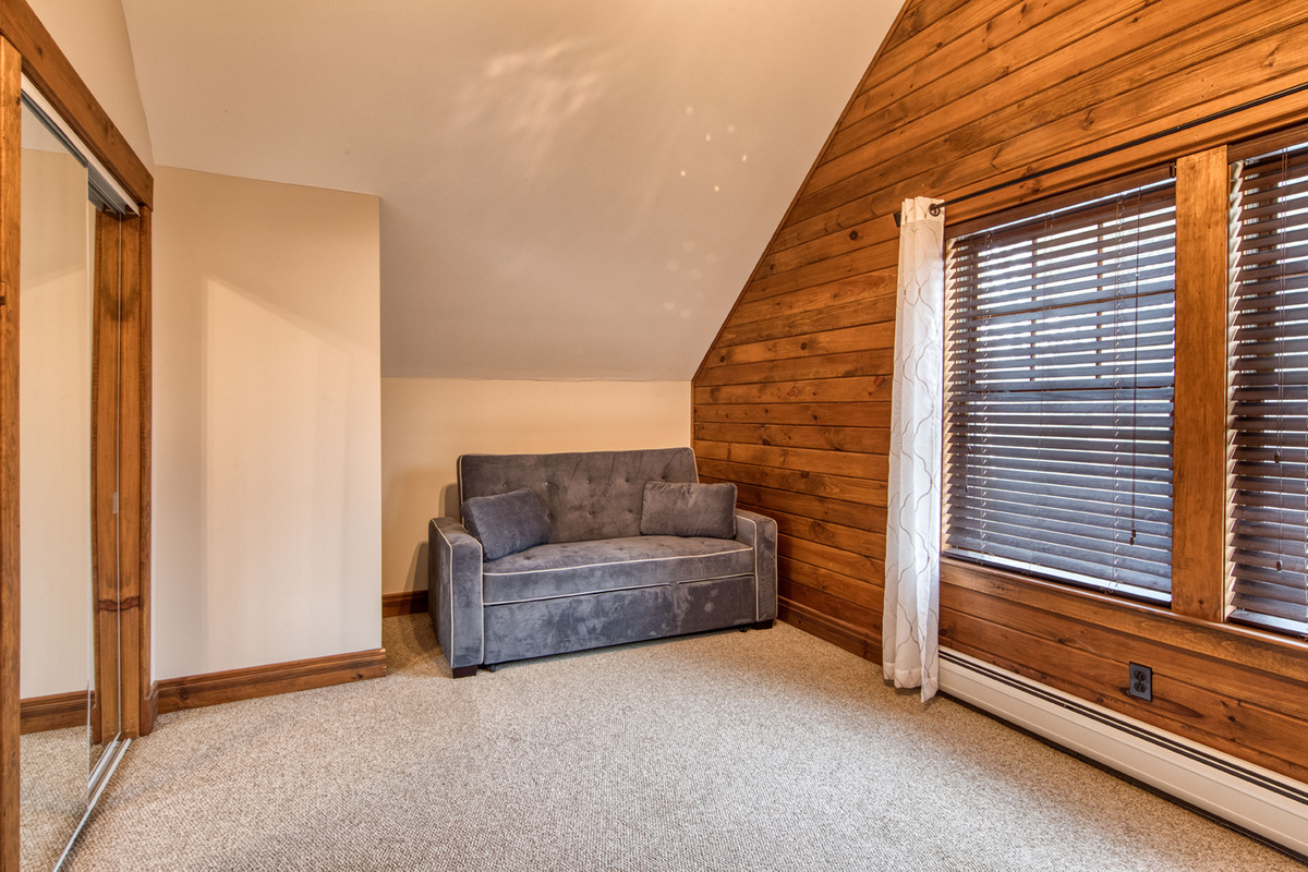 Spacious bedroom offers both sleeping and lounging space with a queen bed and sleeper sofa.