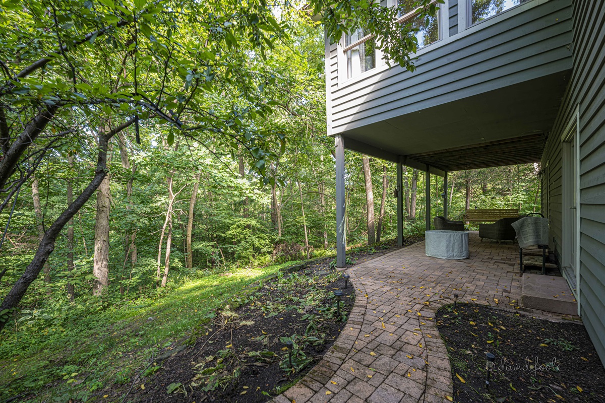 Covered patio with gas fire table, seating, and porch swing