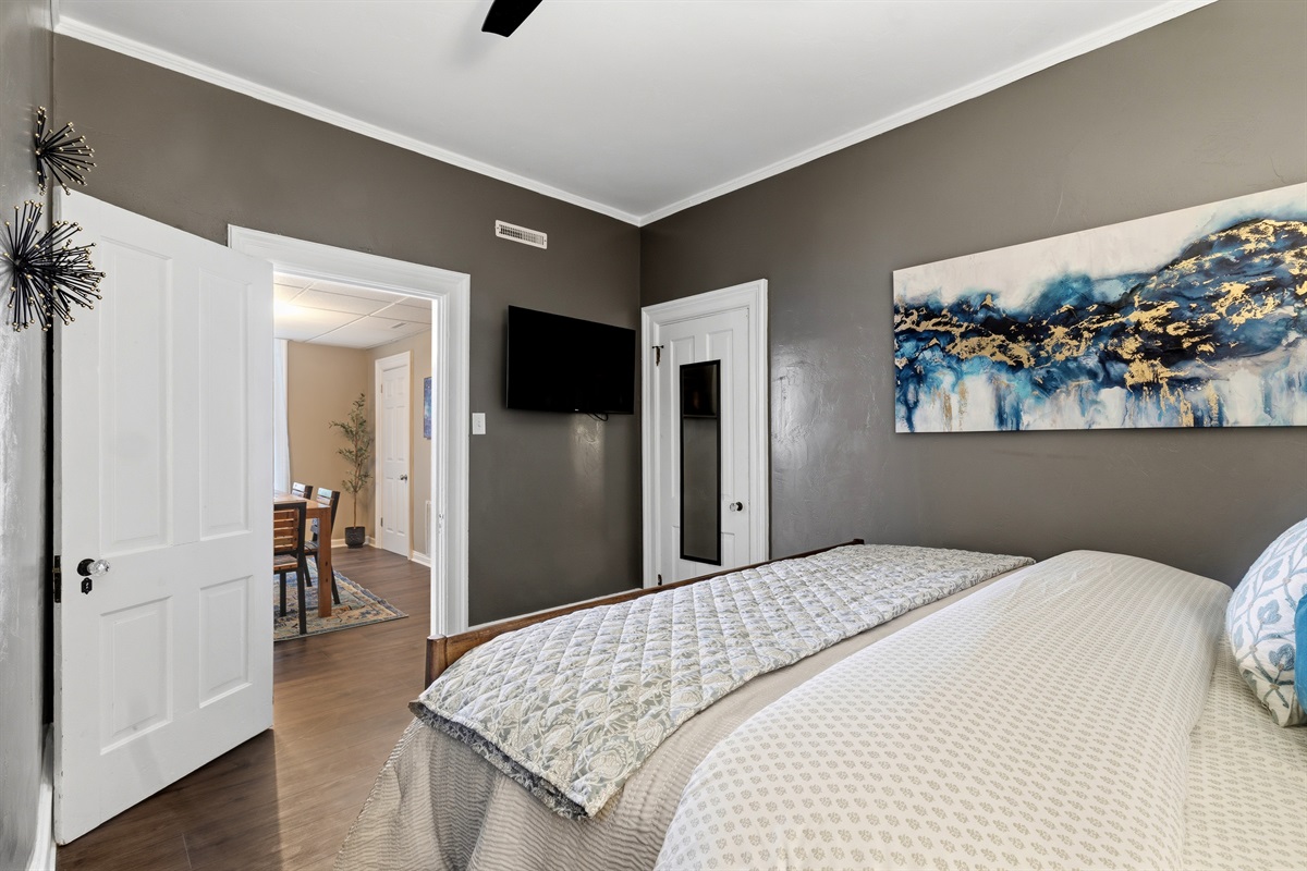 King bedroom includes a wall-mounted smart TV and opens directly to the dining area