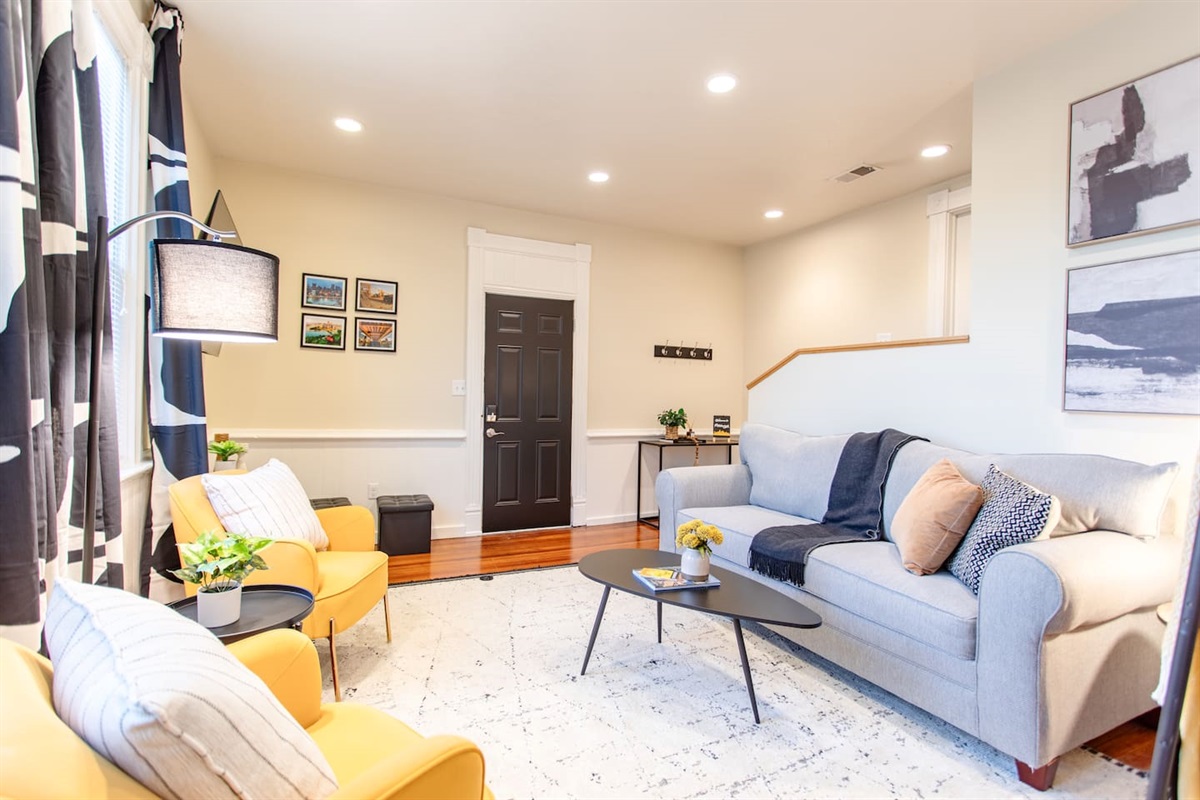 A warm and inviting living area featuring a plush sofa, soft lighting, and a dedicated workspace with a sleek desk and comfortable chair, perfect for productivity and relaxation.