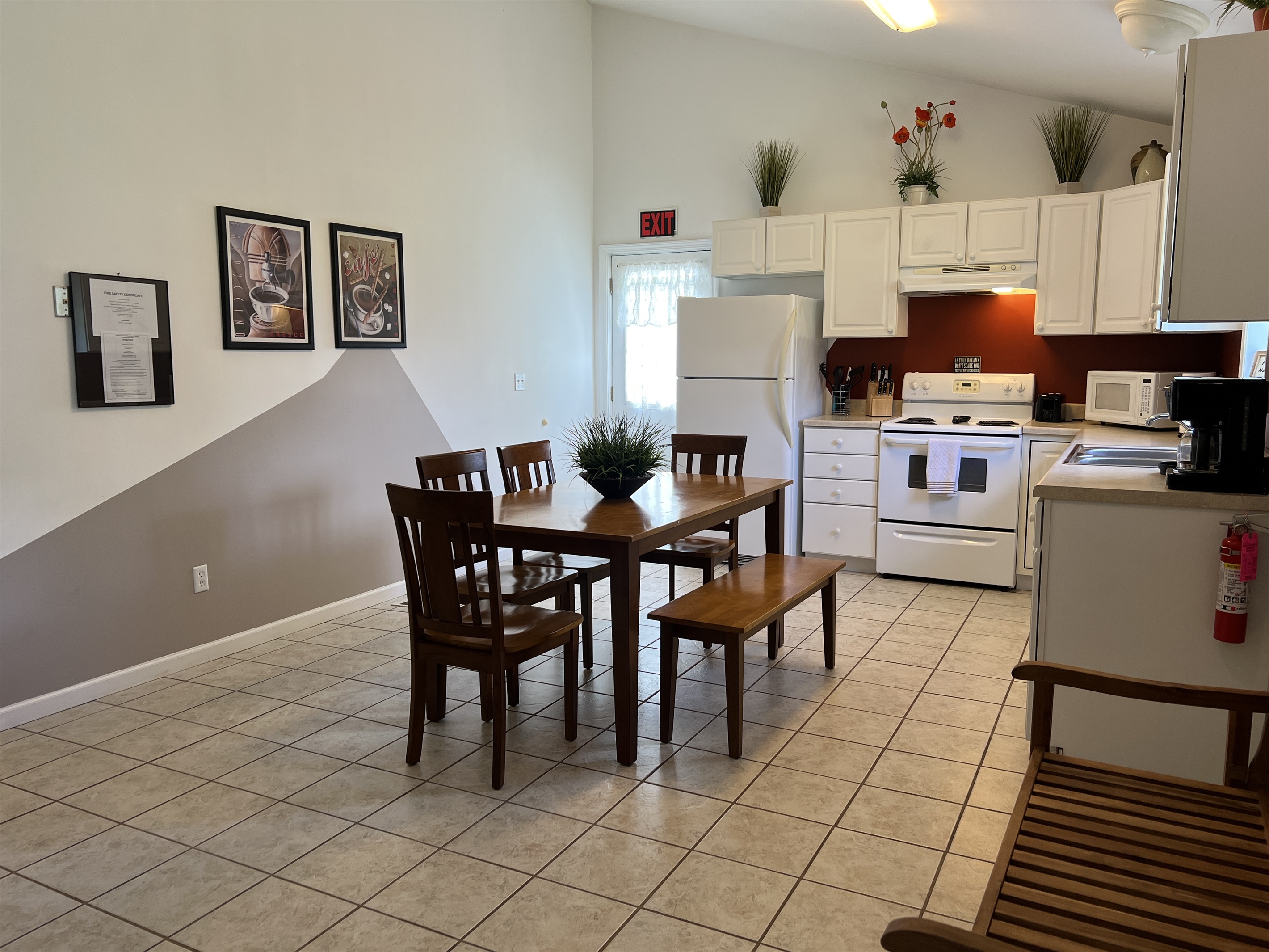 The Federal House Apartment 2 dining  table with seating for six. The exit door on the  left leads to the back deck and grill area.