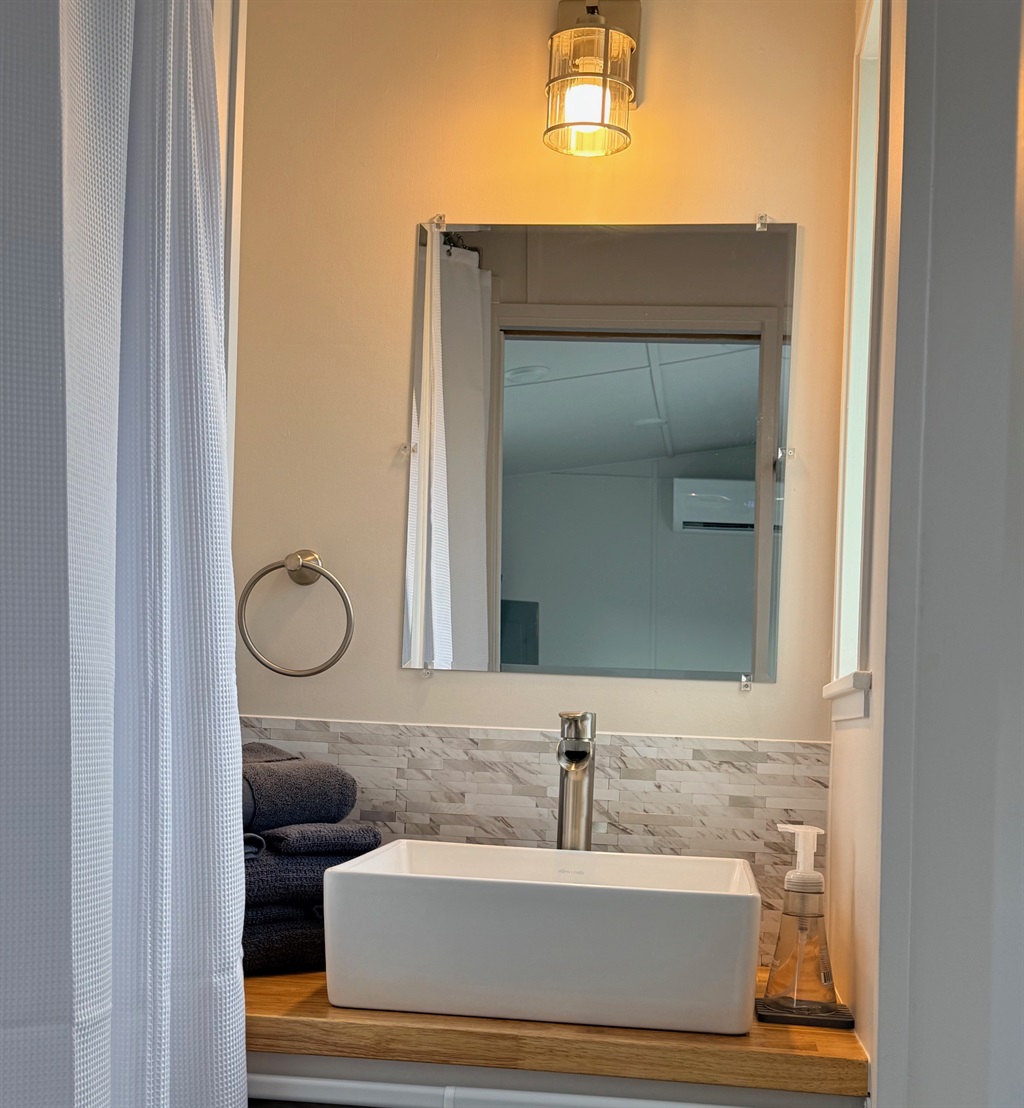 Nice size bathroom with shower, sink and residential toilet
