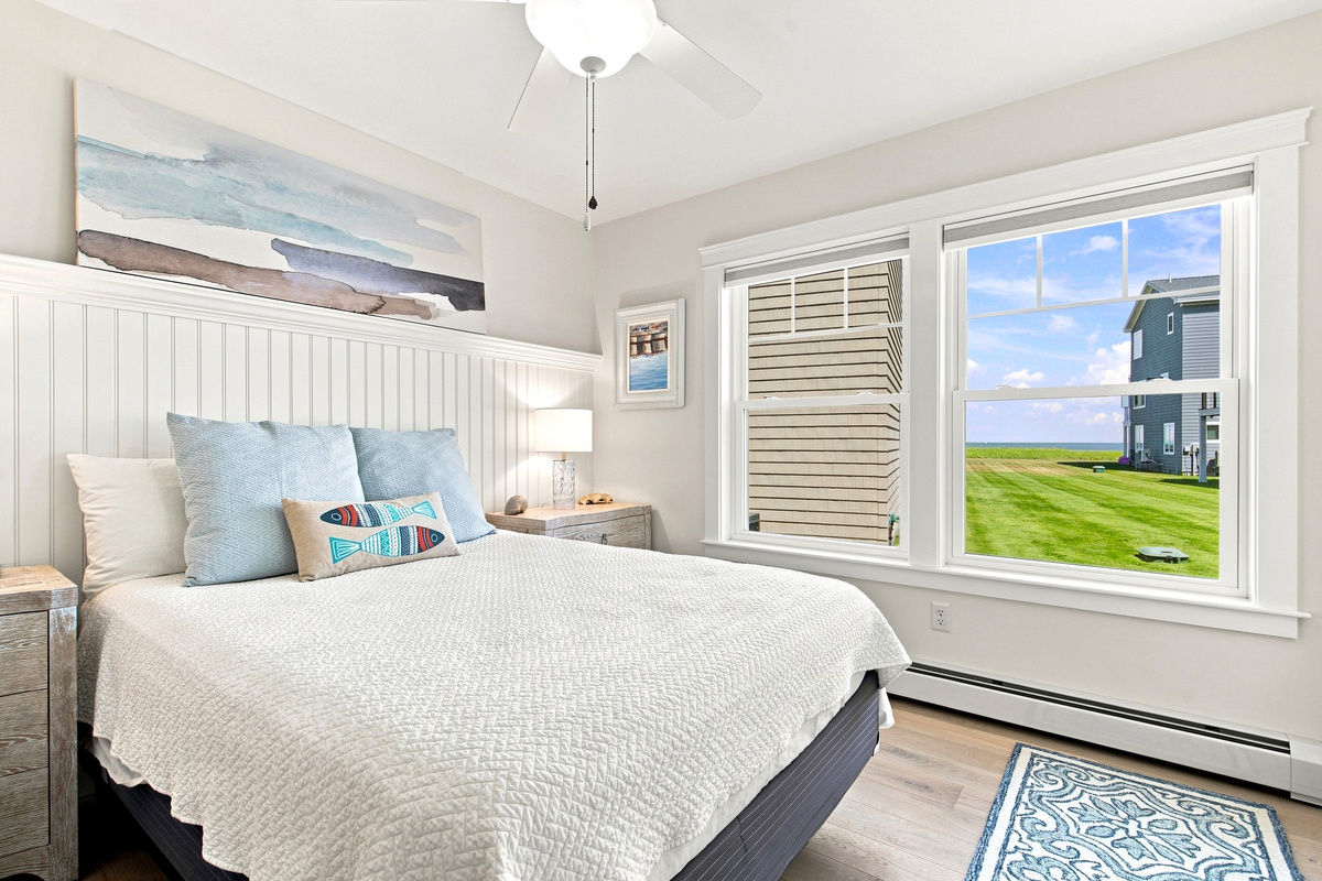 Relax in this serene coastal bedroom while enjoying beautiful views of the ocean just outside the window.