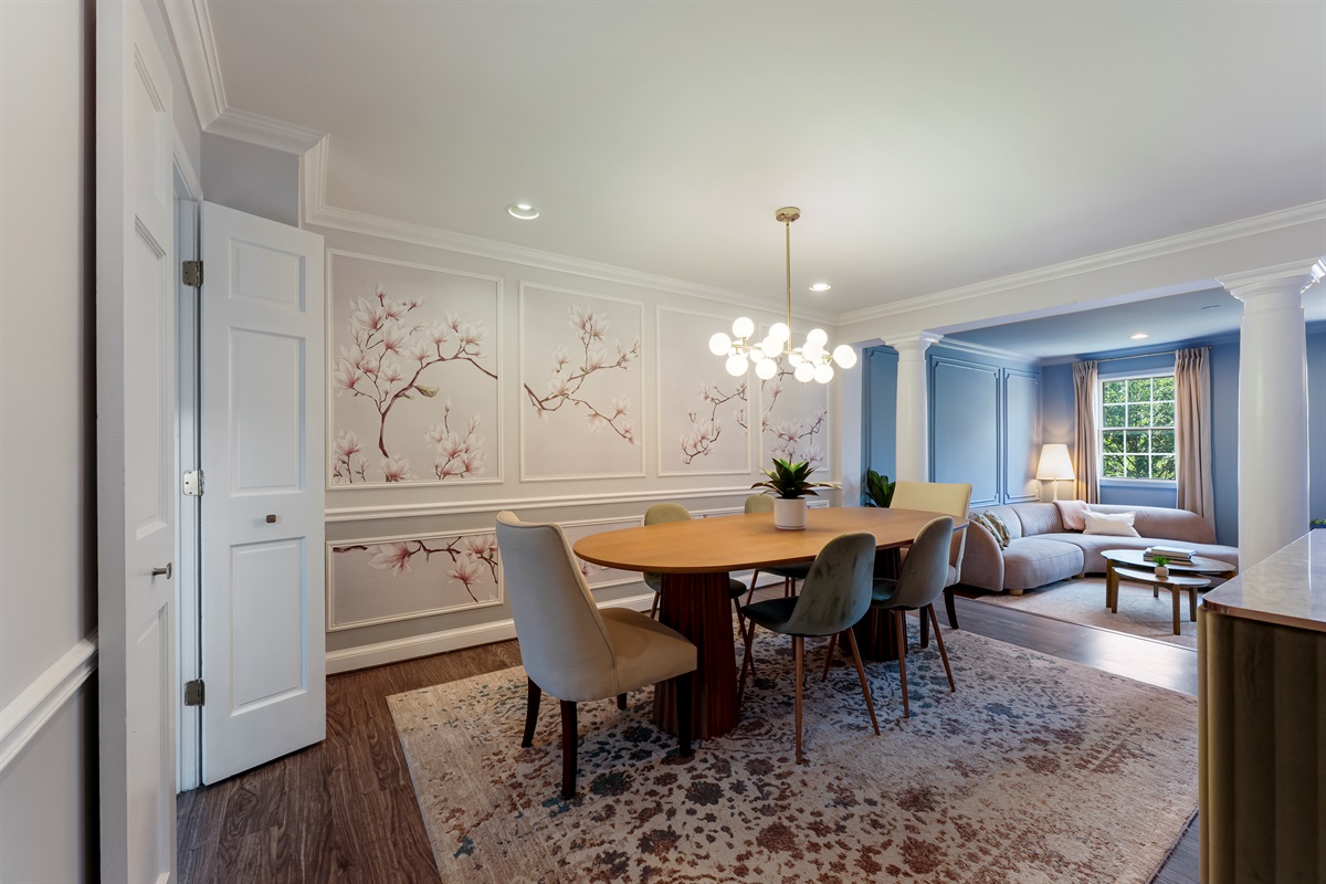 Elegant dining area with custom floral wall panels, modern chandelier, and seamless flow into the living room