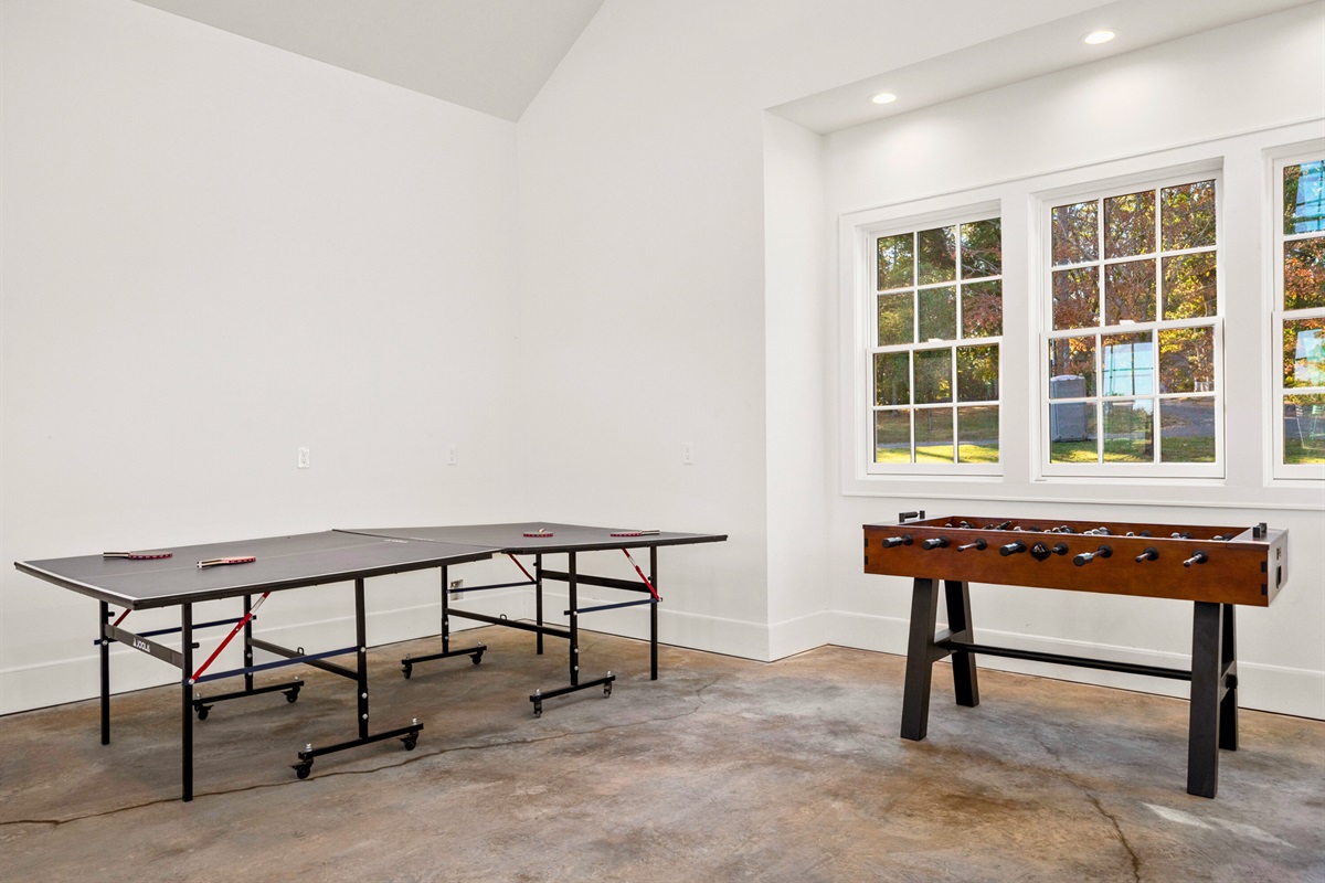 Game room with ping pong and open floor space for fun.