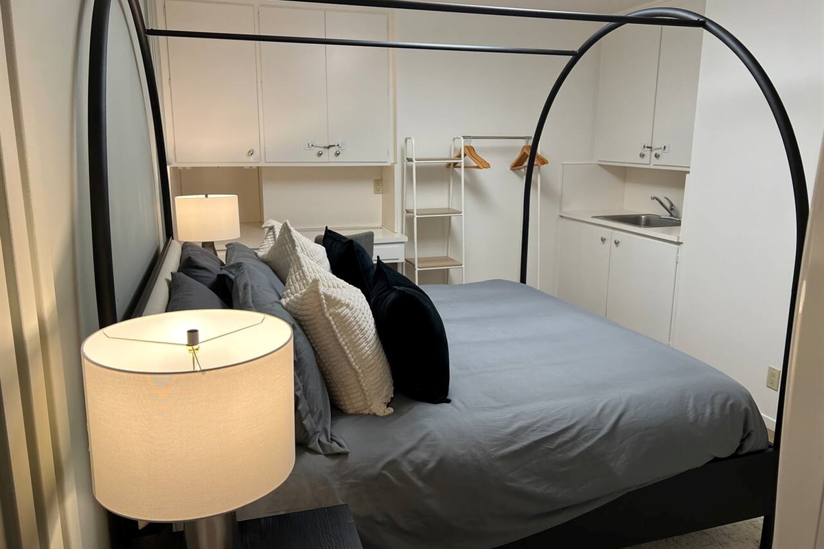This bedroom has a private coffee bar with a sink, personal coffee maker, and mugs. There is also a desk and chair for your use.