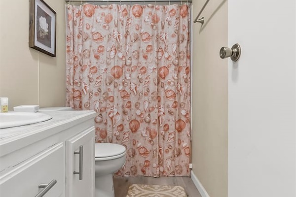 Clean vanity with marble-style countertop, mirror, and essential toiletries provided.