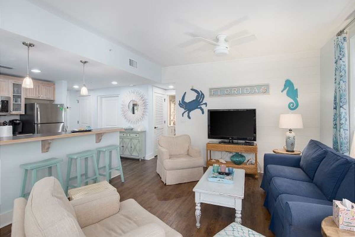 Living room with HDTV and sleeper sofa, looking toward the kitchen bar and entry