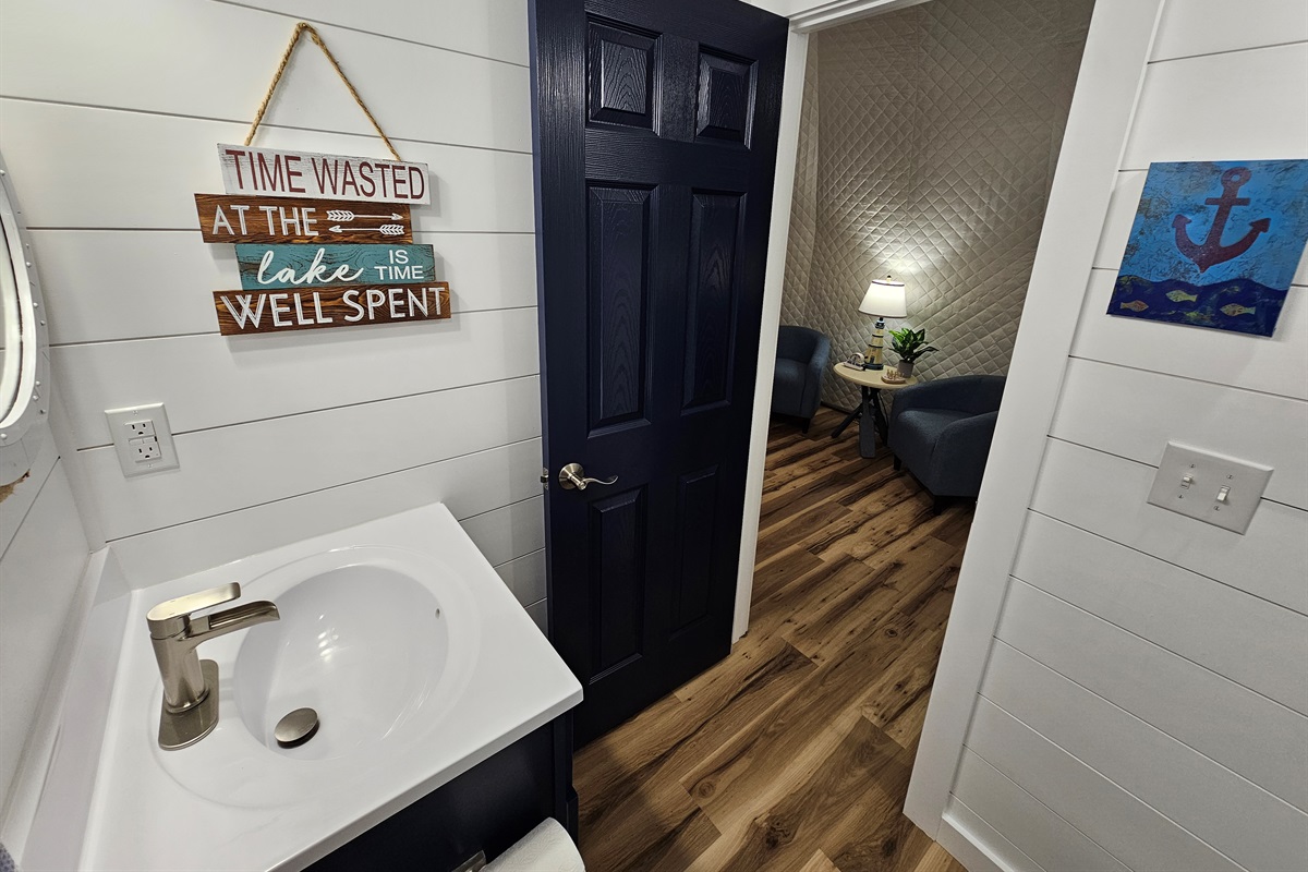 Bright, clean bathroom with lake-themed décor and convenient access to the main dome living space