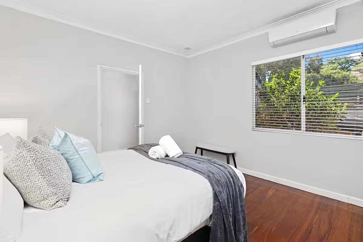 Soft bedding, natural light and timber floors give this bedroom at Sasha’s Cottage on the Hill a simple, welcoming feel.