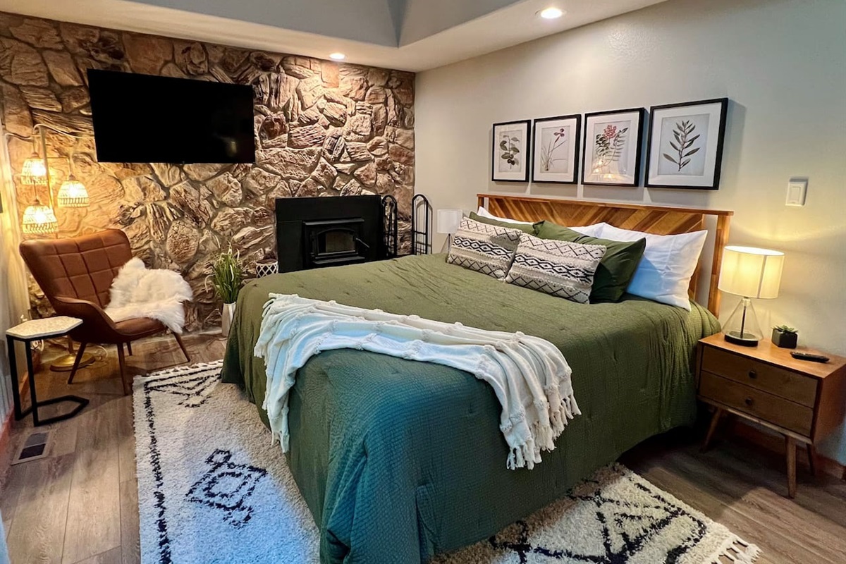King bedroom with Wood Burning Fireplace, TV, Relaxation Station, and deck access
