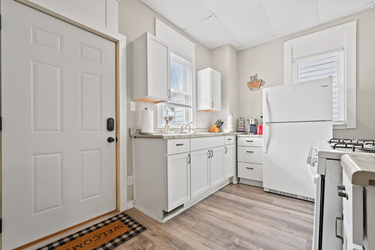 Practical and stylish kitchenette equipped with a stove, microwave, and refrigerator for your stay.