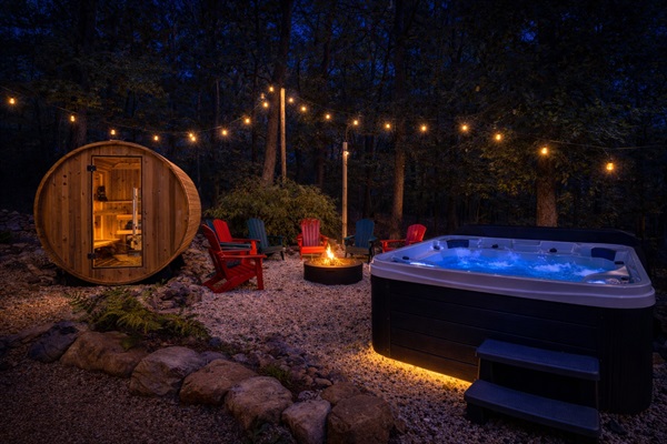 Soak in the glowing hot tub, warm up in the cedar barrel sauna, then gather around the crackling fire pit — all three just steps from your back door under a canopy of string lights.