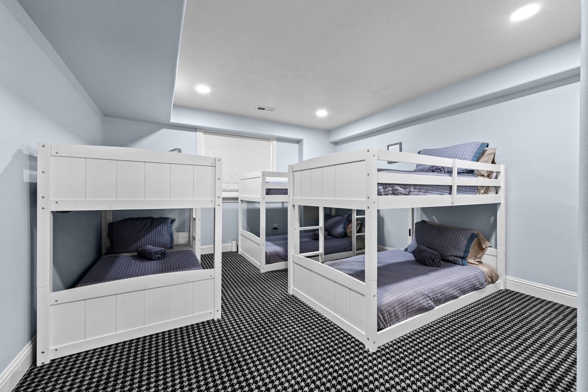 The thoughtfully designed bunk room features three twin-over-twin bunk beds, crisp modern finishes, and sleeping space perfectly suited for younger guests or larger groups.