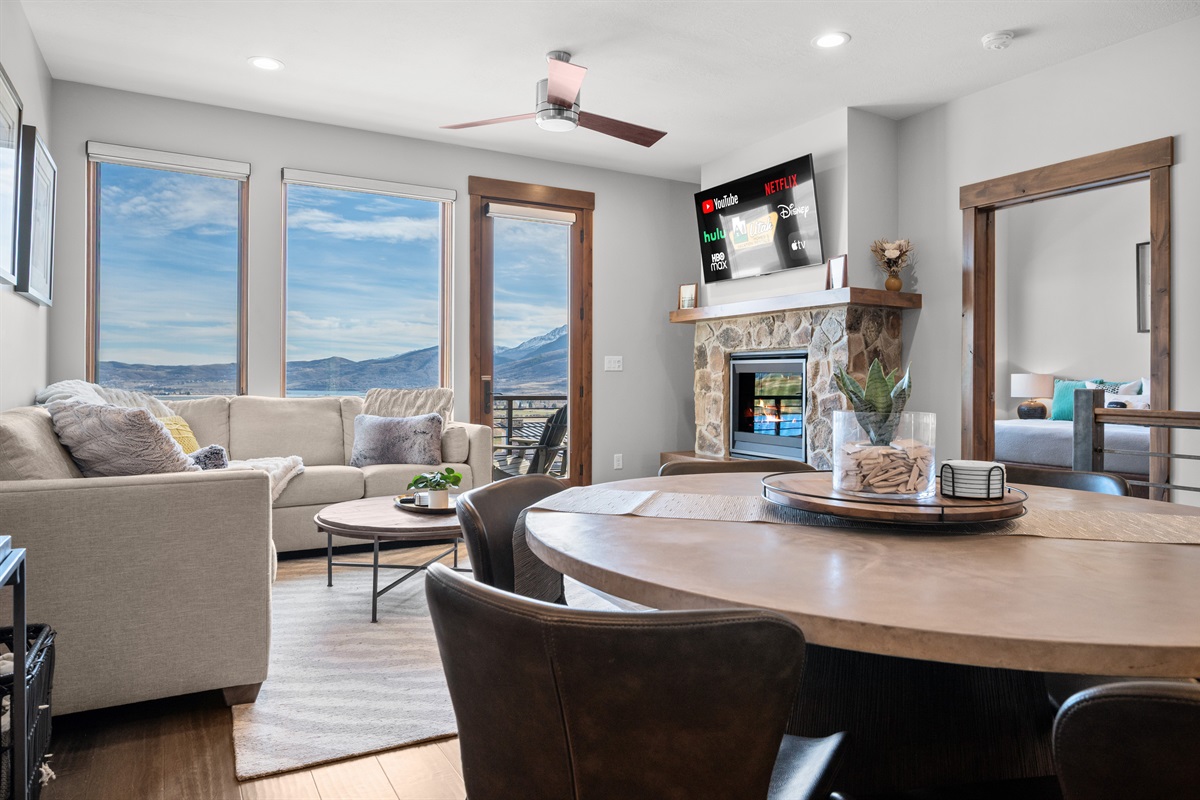 Bright open-concept living space with panoramic mountain views and cozy fireplace