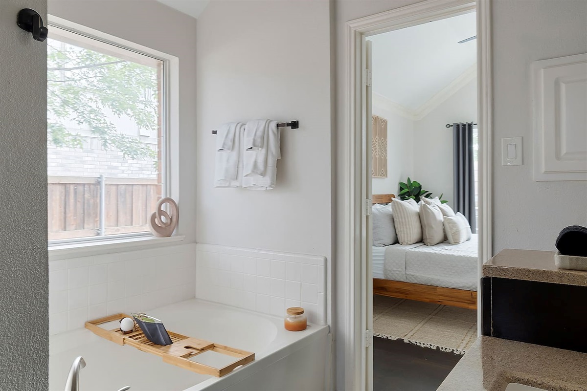 Step into this luxurious bathroom featuring a sleek sink and mirror combo, a inviting bathtub, and a spacious walk-in shower. Pamper yourself in style and comfort.
