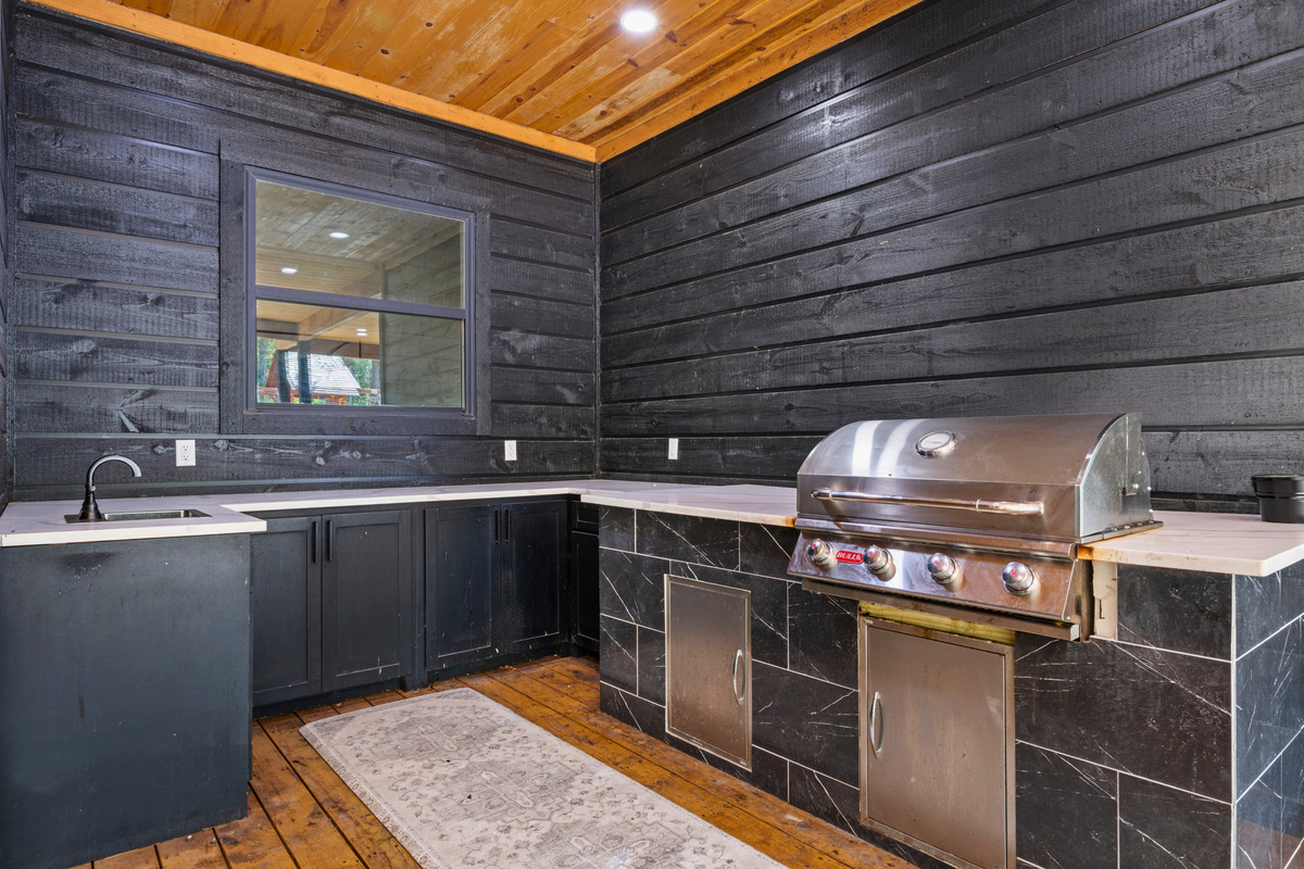 Cook up your favorites in the outdoor kitchen, complete with a built-in grill, counter space, and everything conveniently tucked beneath the covered deck.