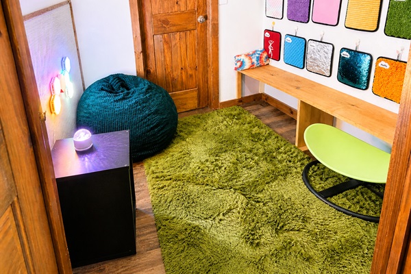 Sensory room with calming lights, textiles, and bean bag.