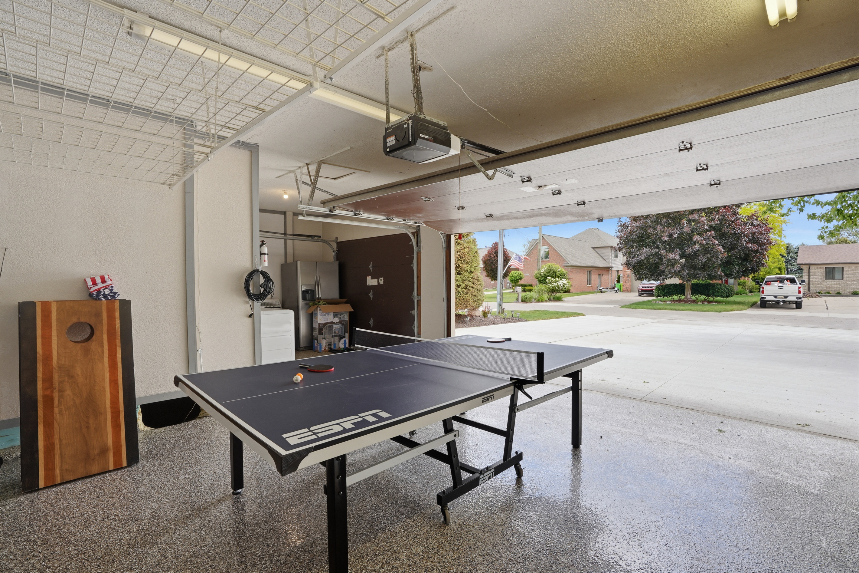 Spacious garage game lounge with ping pong table and open layout. Bright, clean, and versatile space perfect for entertainment, kids’ activities, or casual group hangouts with direct driveway access.