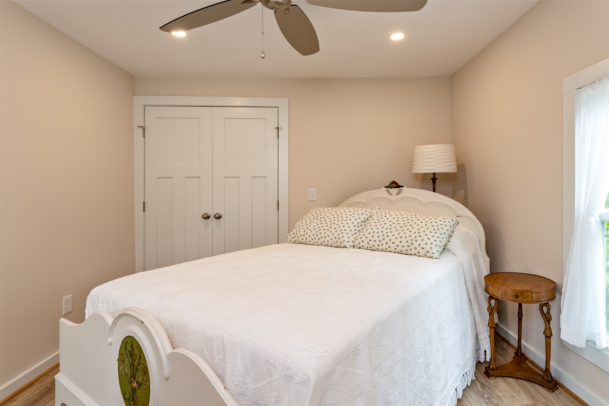 Charming bedroom with unique décor, a ceiling fan, and crisp white bedding for comfort and style. Bedroom #2 double