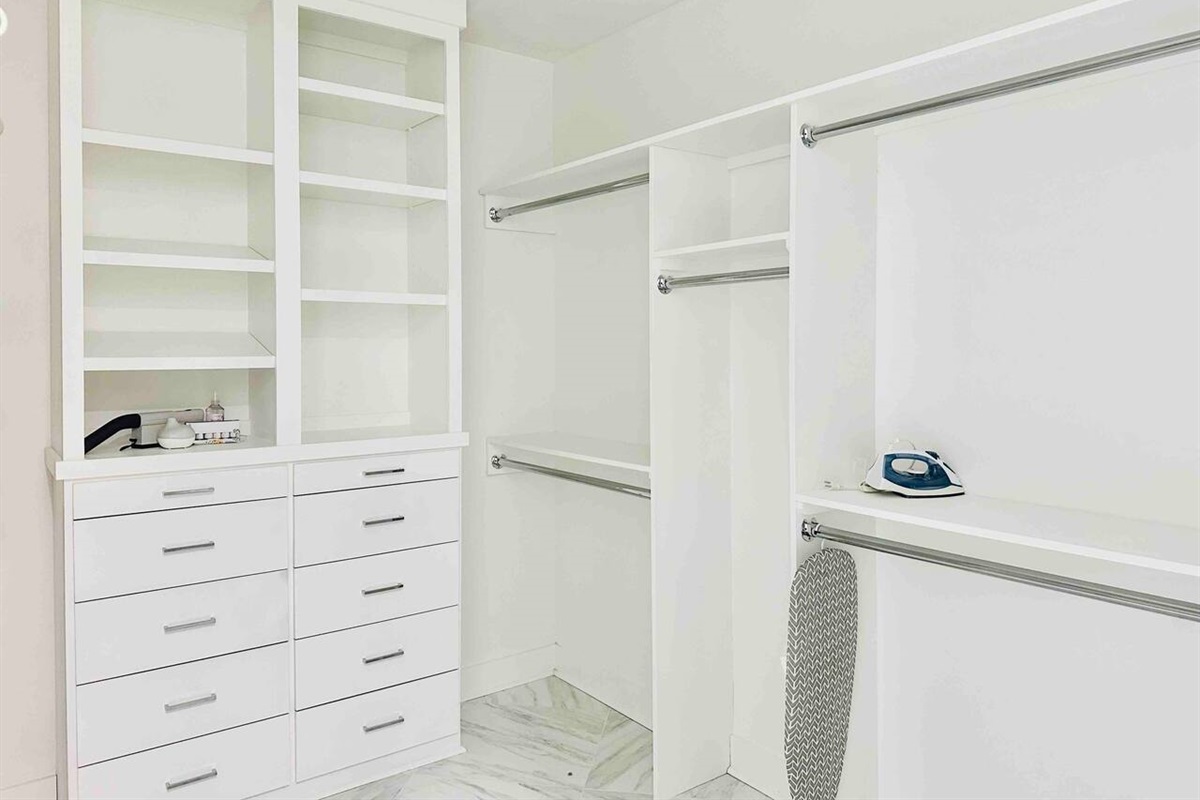 The spacious walk-in closet has plenty of storage for your clothing and luggage. We didn't forget the iron or ironing board.