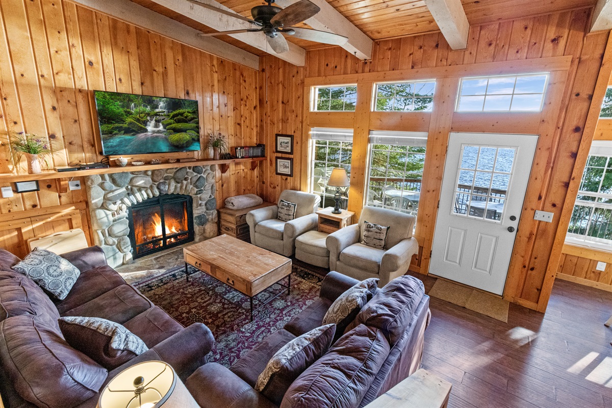 Great room with river-rock gas fireplace and 60" smart TV — McCall Idaho lake house rental