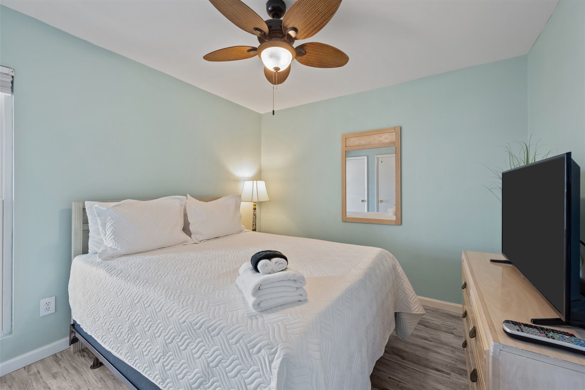 Cozy queen bedroom designed for restful nights after a day by the water
