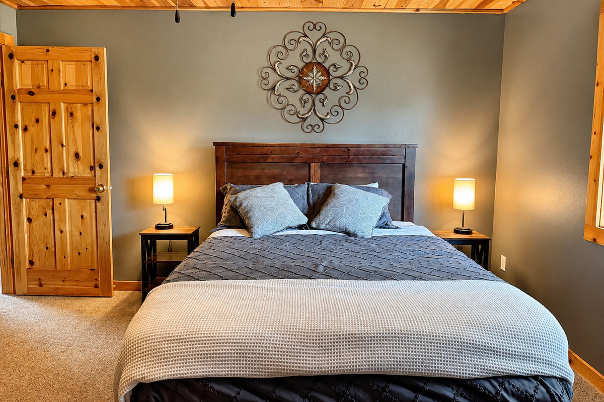 A closer look at the bedroom shows a cozy sleeping setup with bedside lighting and plenty of room to settle in.
