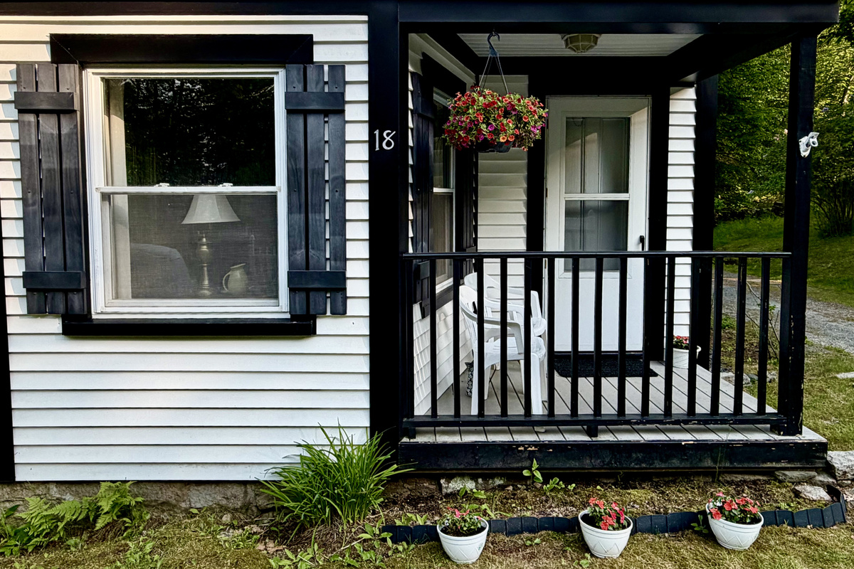 Start your morning with coffee on the front porch, surrounded by summer blooms. This cozy seating area perfectly captures the quiet, slow-paced charm of Somesville’s historic district. A peaceful spot to plan your day's Acadia adventures.