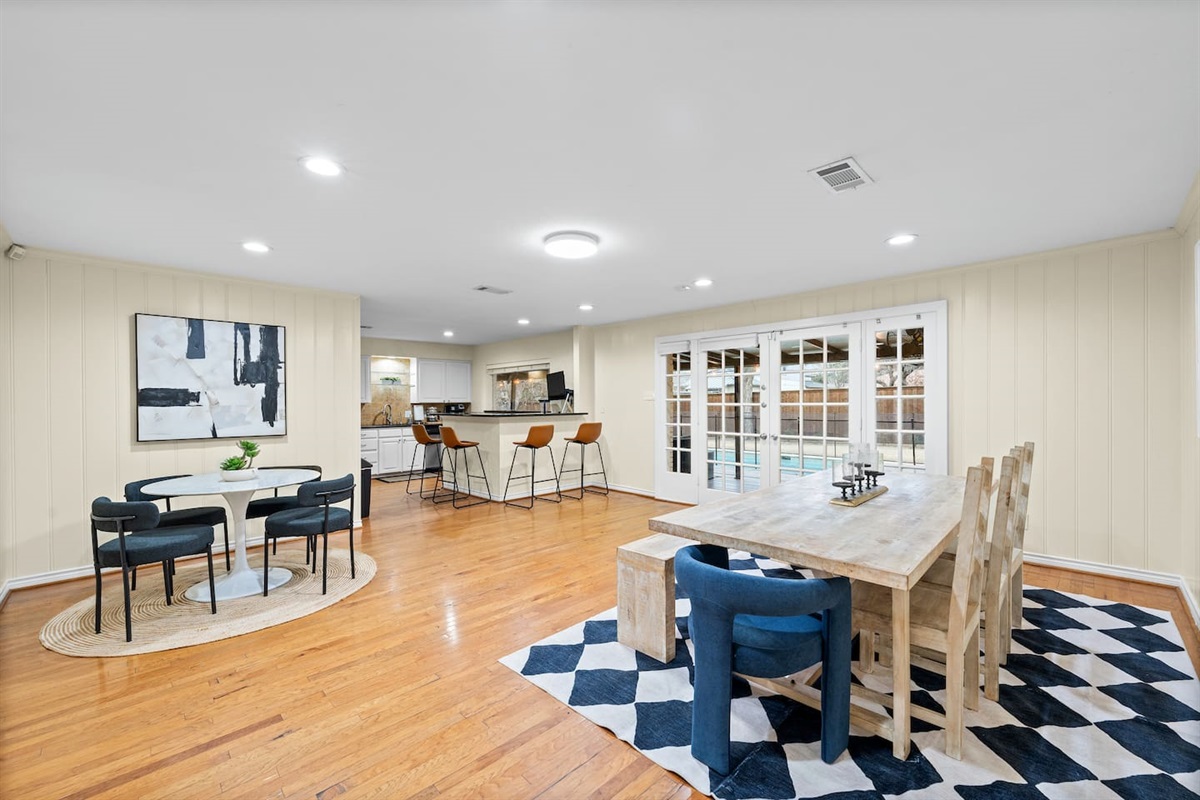 Comfortable seating for 16 people in this open-concept dining and kitchen area. Plenty of natural light and direct access and visibility into the backyard.