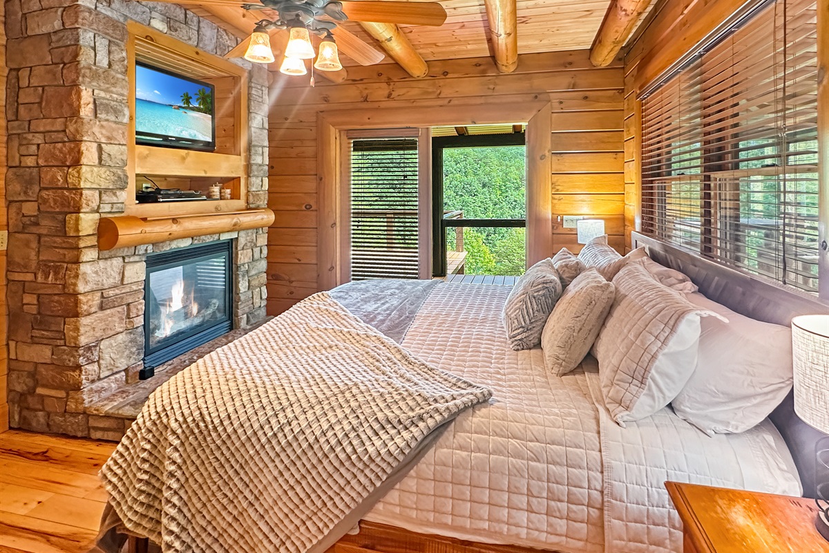 Master Bedroom Retreat: Indulge in rustic charm with a fireplace and scenic forest views!