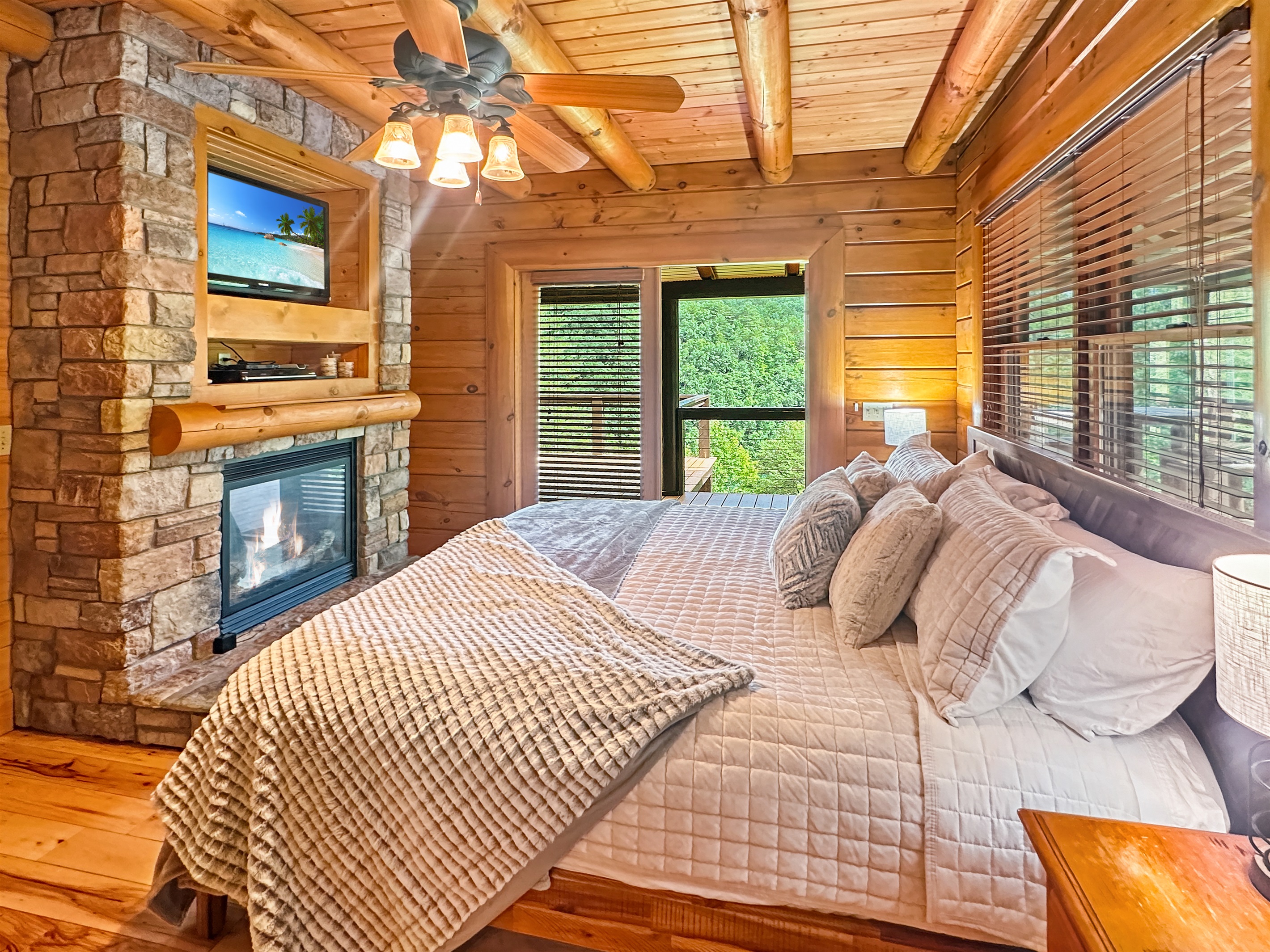 Master Bedroom Retreat: Indulge in rustic charm with a fireplace and scenic forest views!