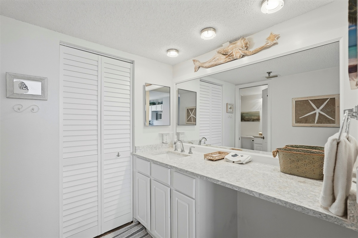 The common bathroom offers a clean, functional layout with a walk-in shower, toilet, and vanity. It also includes plenty of closet and storage space, providing added convenience for guests during their stay.