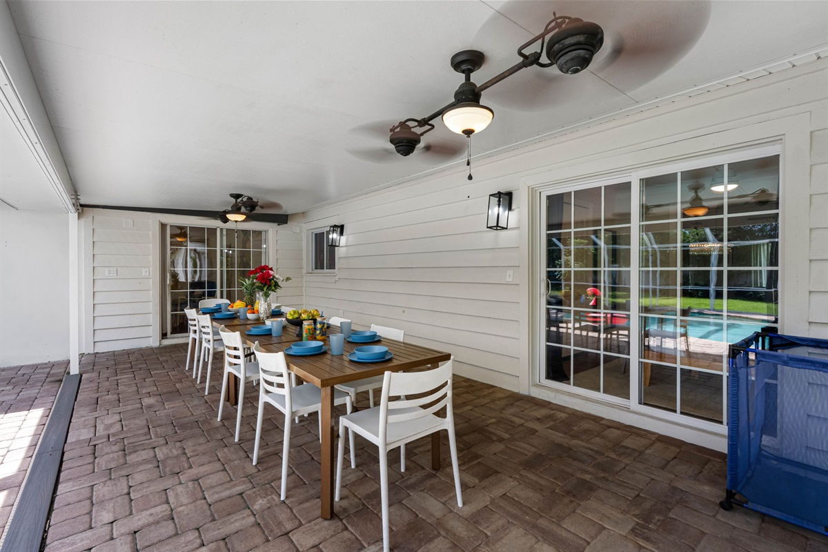 A spacious covered lanai provides ample room for entertaining, complete with a large dining table overlooking the screened pool.