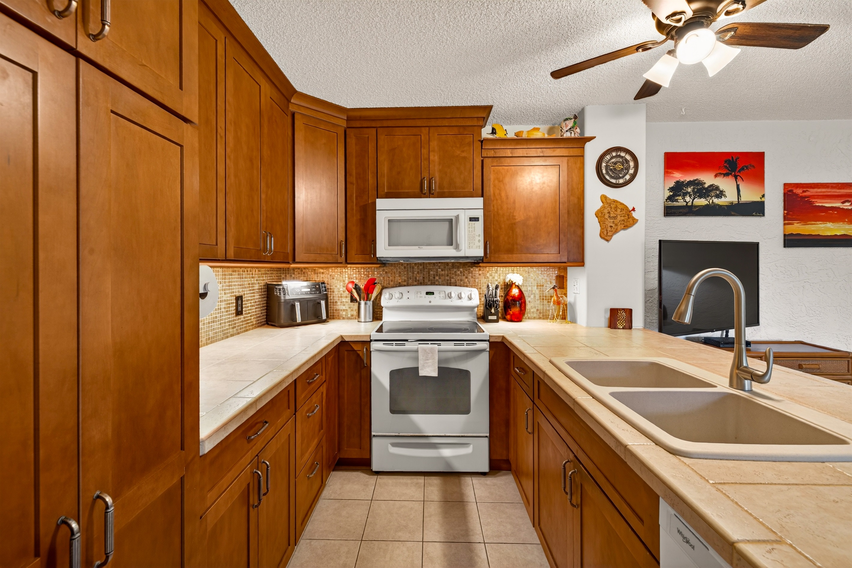 Well-appointed kitchen featuring full-size appliances, including stove, microwave, air fryer, and dishwasher for easy meal prep.
