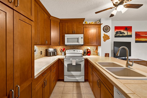 Well-appointed kitchen featuring full-size appliances, including stove, microwave, air fryer, and dishwasher for easy meal prep.