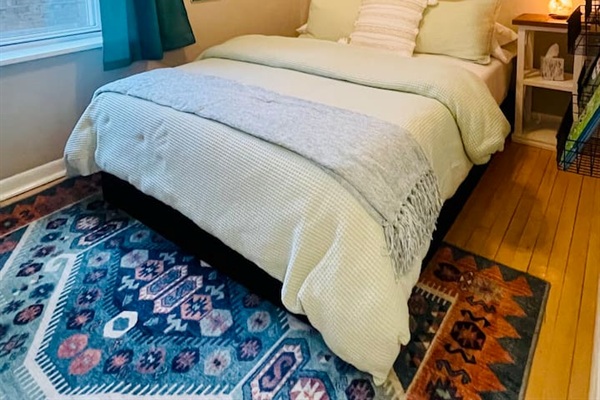 Comfortable bedroom with stylish rug and cozy bedding.