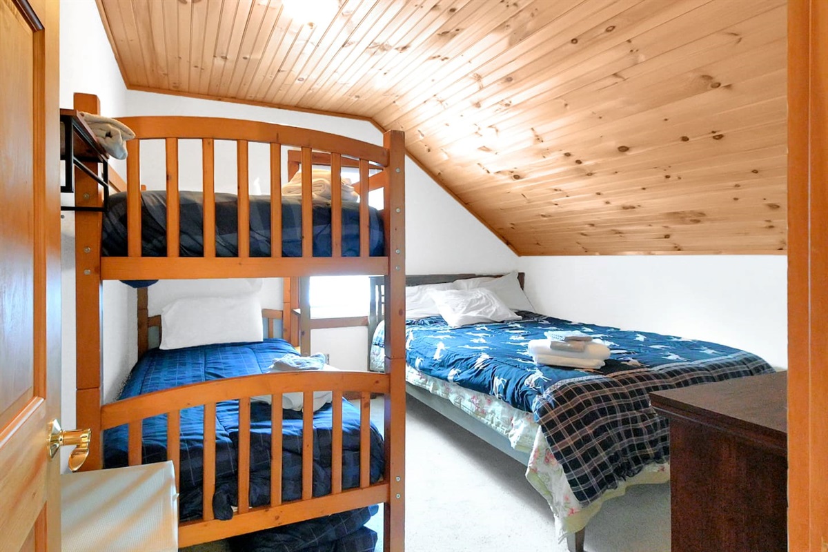 The second bedroom features another twin bunk plus a full bed, ideal for families or groups.