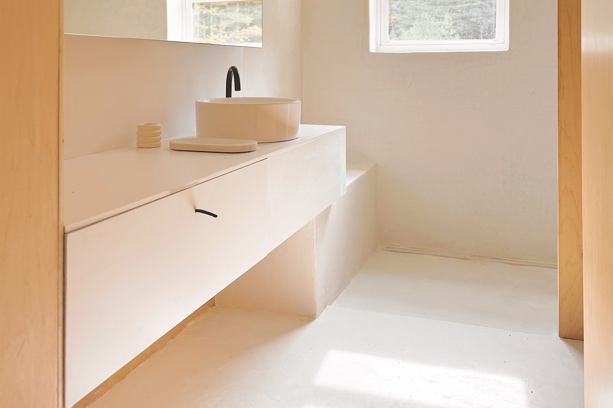 The full bathroom is located upstairs, and features an open microcement shower, and enclosed toilet room.