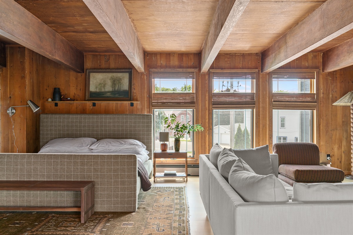 The primary bedroom features a spacious king-size bed, designed for both comfort and style. Bedside tables with lamps add a cozy glow, making it easy to settle in with a book at night or wake gently in the morning light.