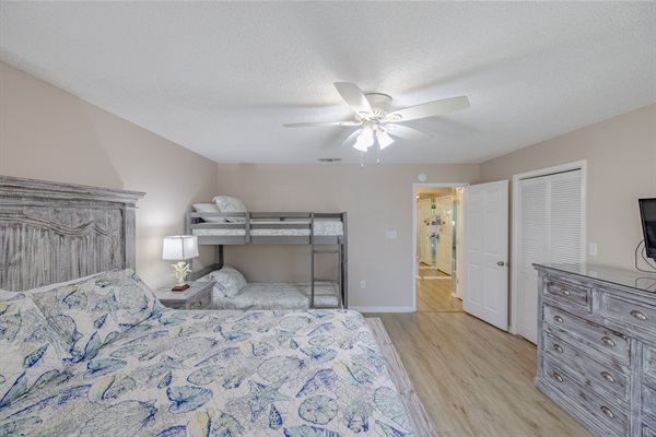 Second bedroom with queen + bunks, smart TV, ceiling fan, bathroom access