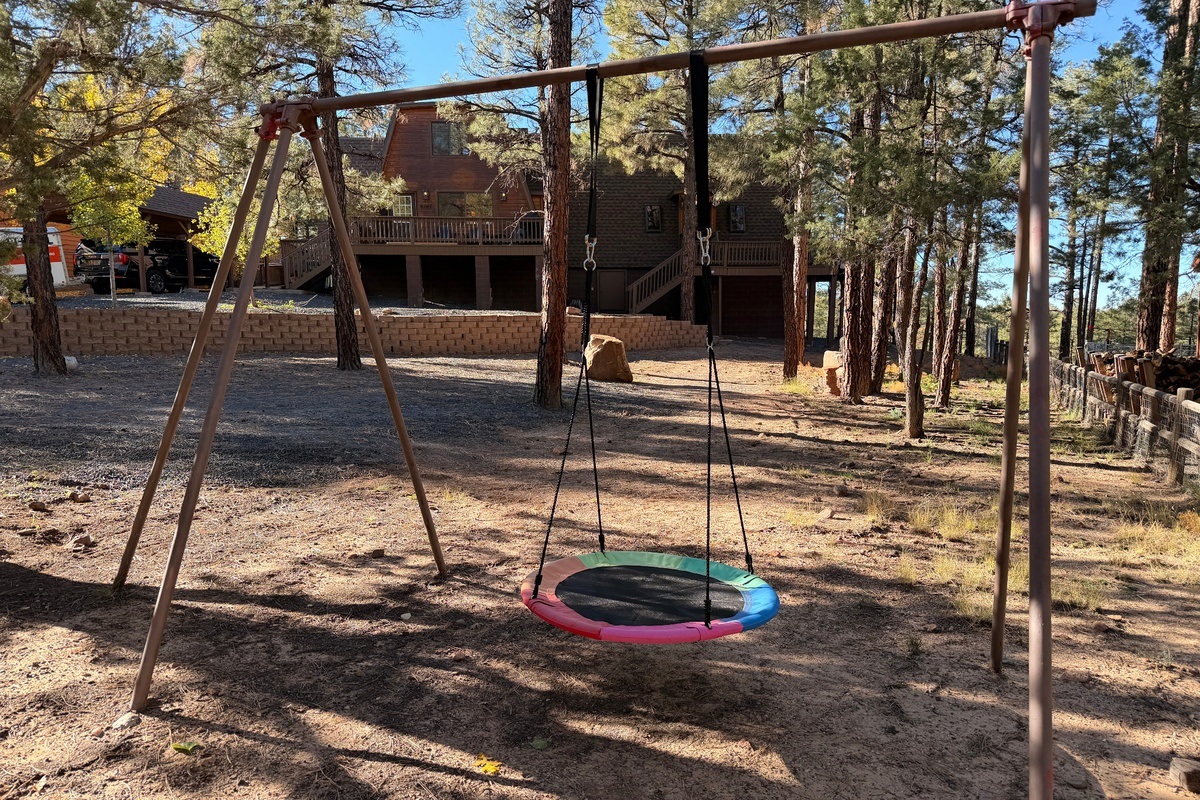 Backyard swing set at Poppywood Pines nestled beneath towering pines in Arizona’s White Mountains 🌲 A family-friendly cabin retreat in Show Low featuring open forest space, fresh mountain air, and room to play—where kids laugh, memories are made, and cabi