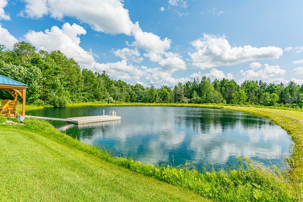 Relax Pond side under a covered pavilion with Adirondack seating and peaceful water views—an unforgettable outdoor experience.