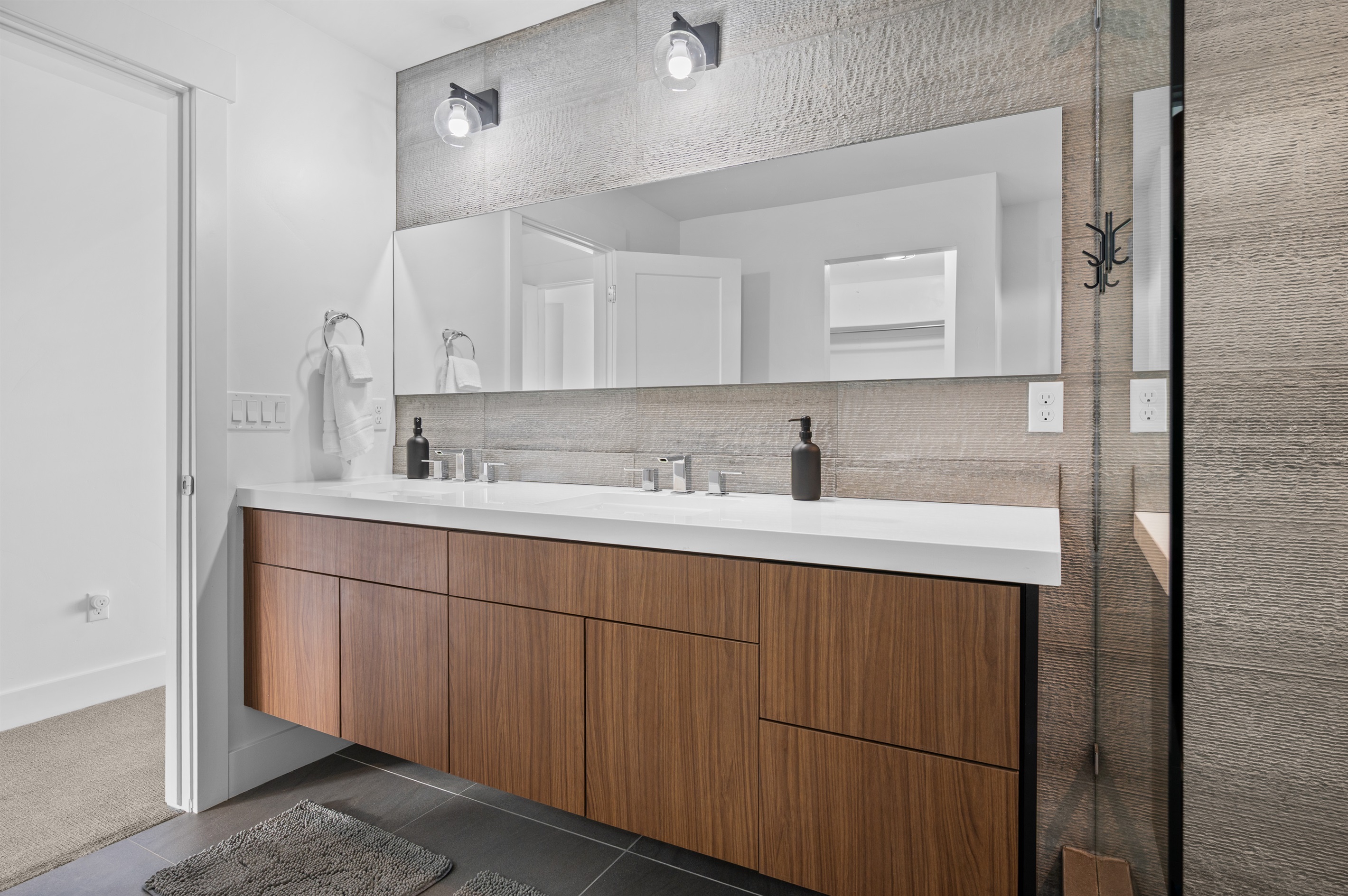 Primary en-suite with dual-sink vanity and elegant modern design.