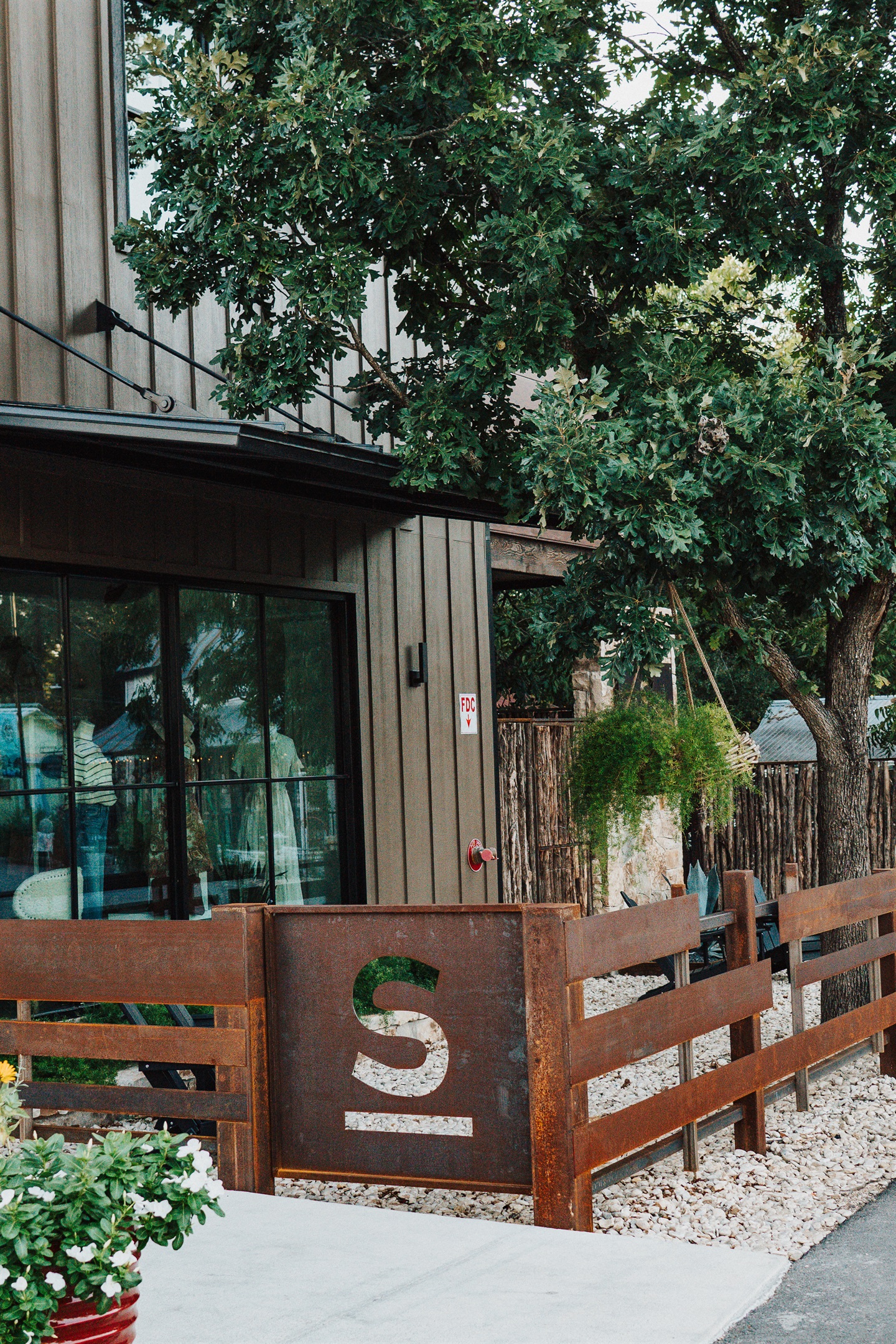Hill Country stone and corral-style fencing carry modern Western design through Gaines Ranch on the Square — character built into every detail.