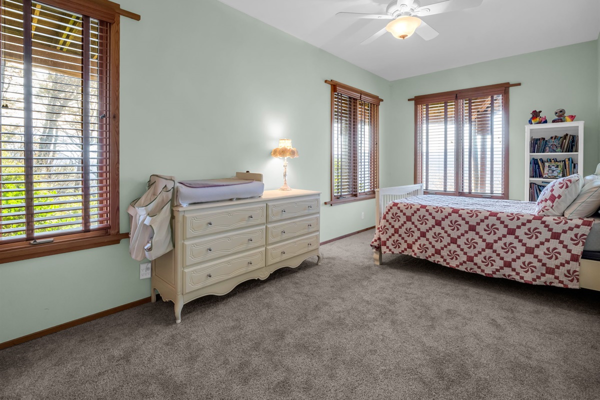Downstairs bedroom with changing table and full bed.