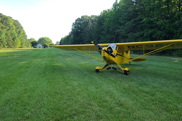Piper cub parked on the runway