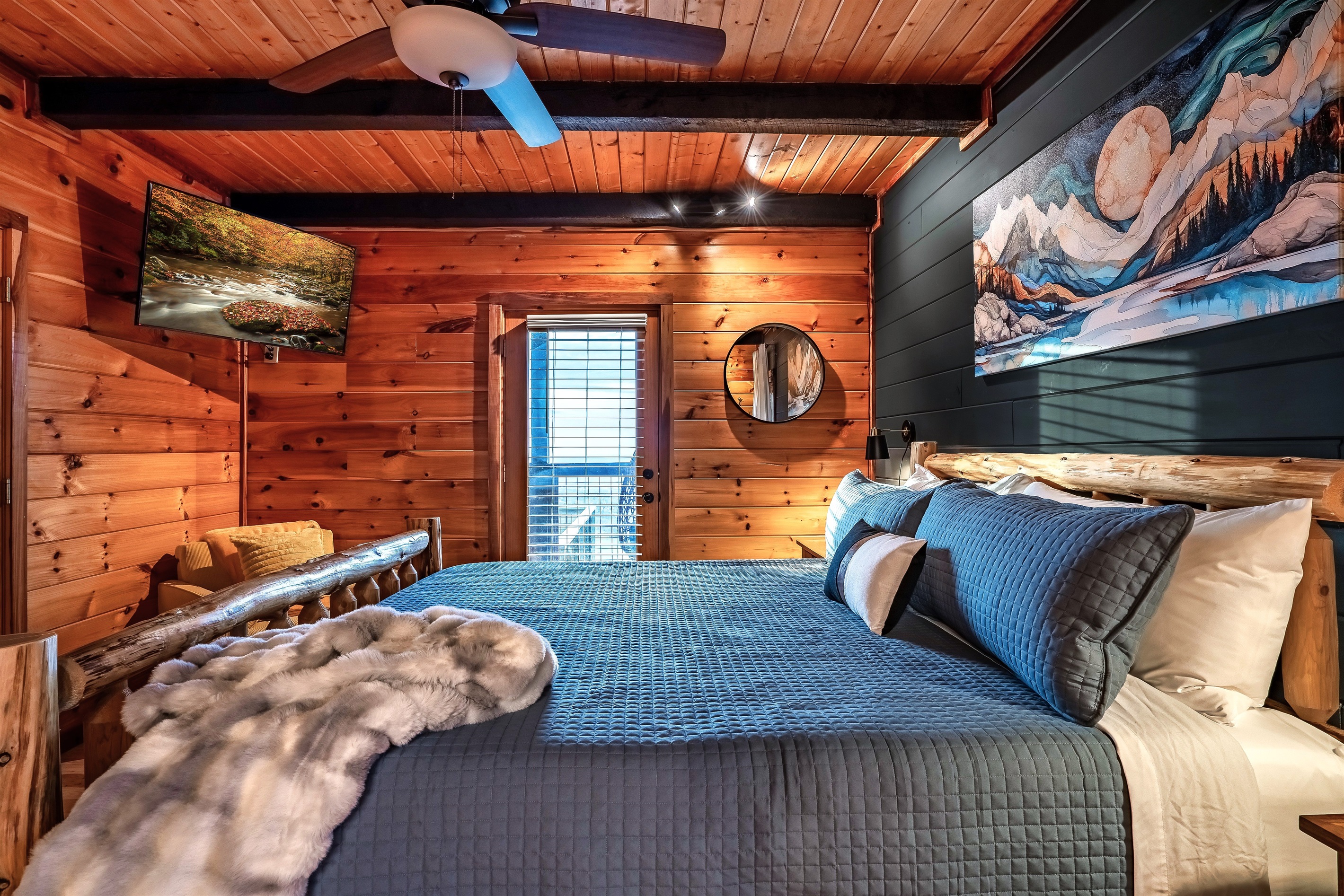 Charming mountain cabin master bedroom with deck access, combining comfort, modern design, and outdoor living for a memorable getaway.