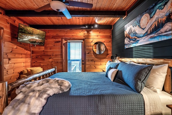 Charming mountain cabin master bedroom with deck access, combining comfort, modern design, and outdoor living for a memorable getaway.